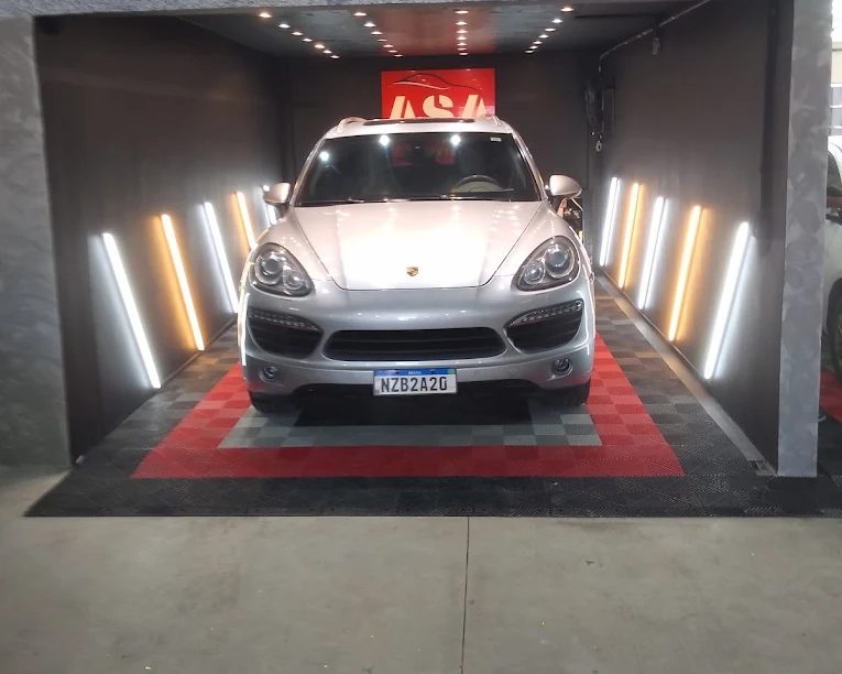 Carro prata no box de entrega da ASA, com iluminação de LED e piso quadriculado vermelho e preto